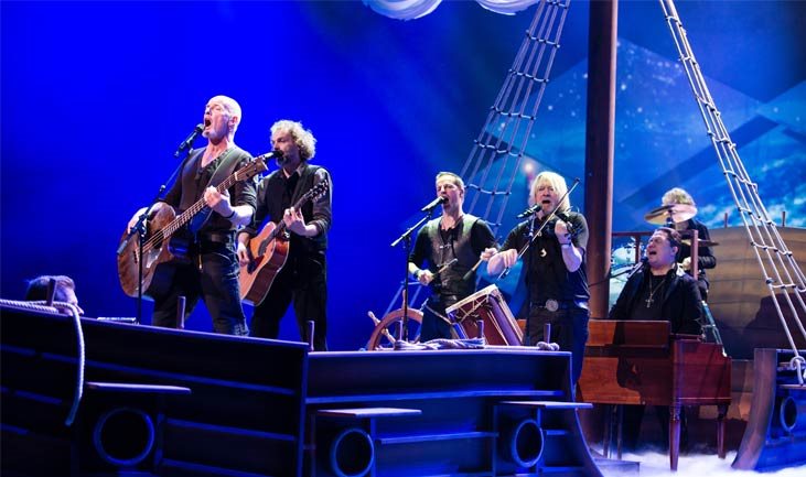 Santiago singend und spielend auf einem Schiff/Boot