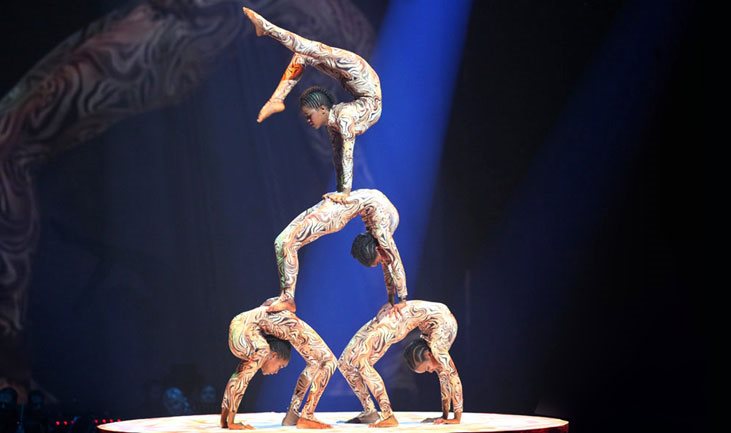 Vier Artisten machen eine Pyramide auf Menschen